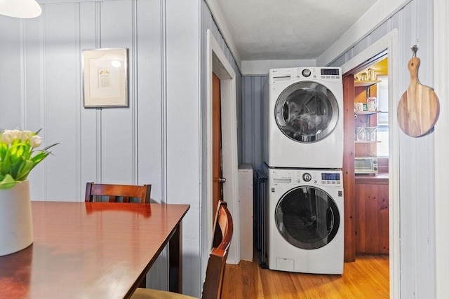 42 Carolina Ave, Boston, MA 02130 - laundry area with estacked washer and dryer, light wood-style floors, and a decorative wall