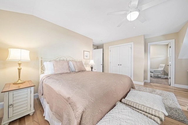 bedroom with lofted ceiling, ceiling fan, light hardwood / wood-style floors, and a closet