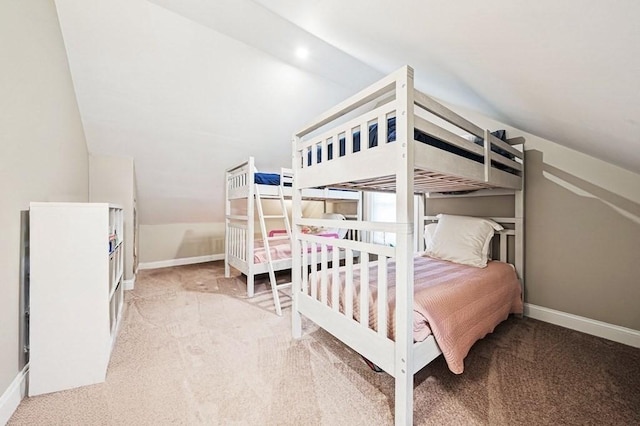 bedroom with light colored carpet and lofted ceiling