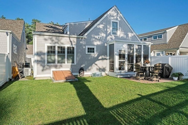 back of house with central air condition unit, a patio, a lawn, and a sunroom