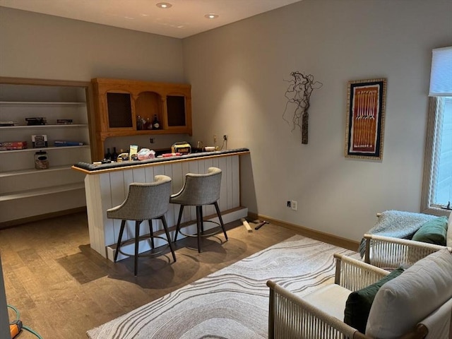 bar featuring baseboards, bar area, and recessed lighting