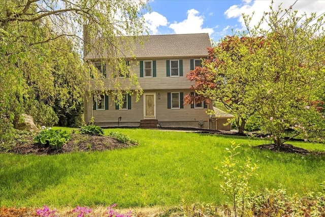 colonial inspired home featuring entry steps, a balcony, and a front lawn