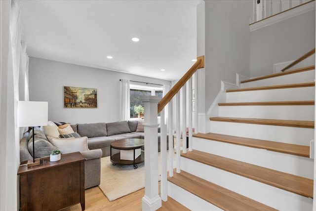 stairway featuring wood finished floors and recessed lighting