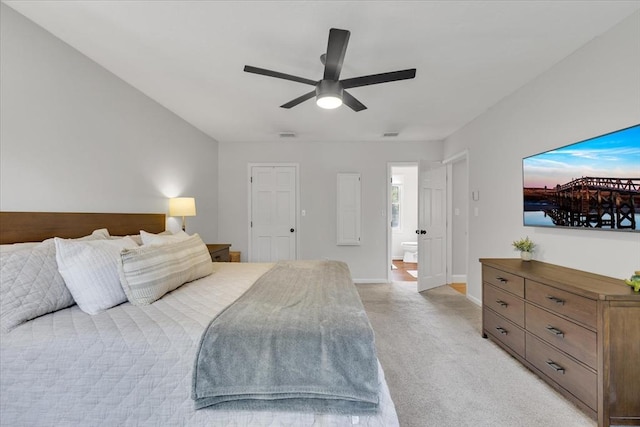 bedroom with light colored carpet, baseboards, ceiling fan, and ensuite bathroom