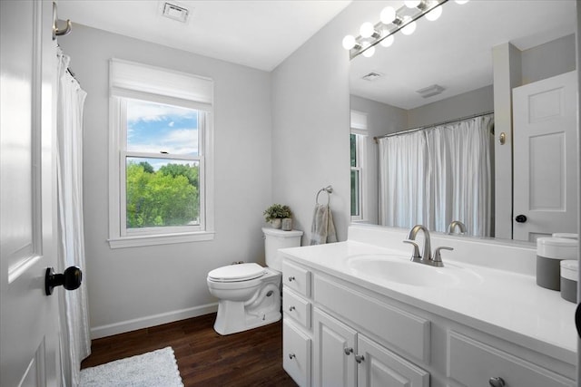 full bathroom with baseboards, toilet, wood finished floors, and vanity