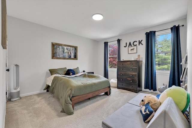 bedroom featuring light colored carpet, multiple windows, and baseboards