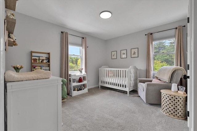 carpeted bedroom featuring a nursery area