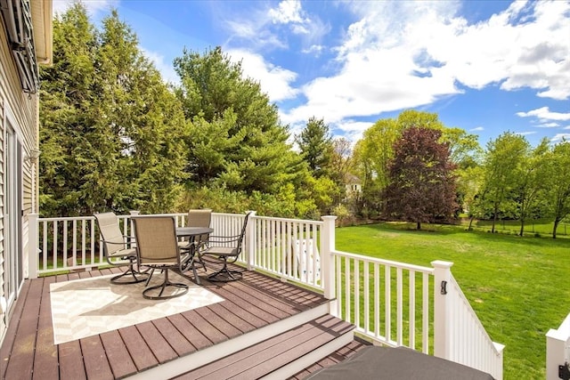 wooden terrace featuring outdoor dining area, a yard, and view of scattered trees