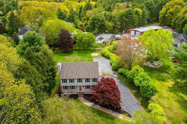 aerial view of property and surrounding area featuring a heavily wooded area