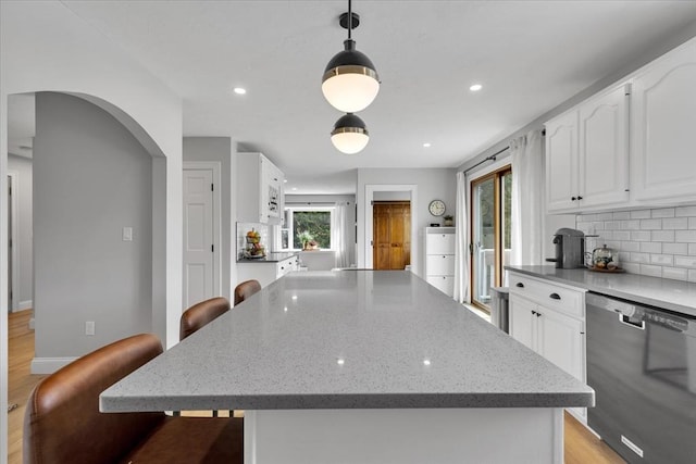kitchen featuring dishwasher, white cabinets, light stone counters, decorative backsplash, and recessed lighting