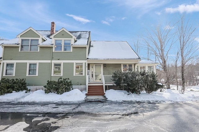 view of front of home featuring covered porch and a chimney