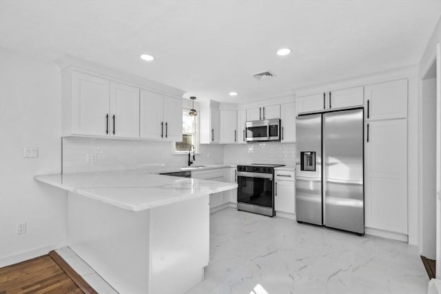 kitchen with stainless steel appliances, sink, white cabinets, kitchen peninsula, and pendant lighting