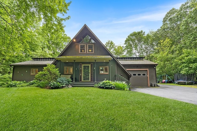 52 Nourse St, Westborough, MA 01581 - a-frame home with asphalt driveway, a garage, a front lawn, and a trampoline