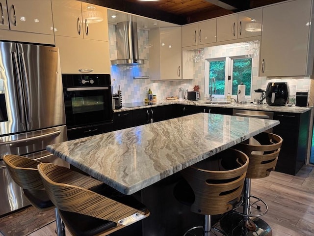 52 Nourse St, Westborough, MA 01581 - kitchen with black appliances, wall chimney exhaust hood, decorative backsplash, a breakfast bar, and a wood ceiling with exposed beams