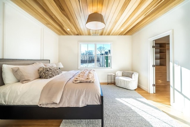 bedroom with light hardwood / wood-style floors and wooden ceiling