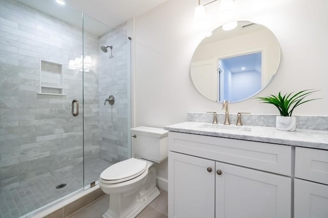 bathroom featuring vanity, toilet, and a shower with shower door