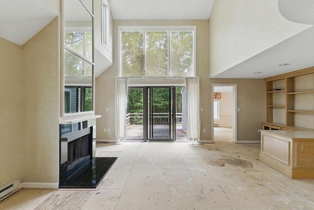 2 Hillside Dr Unit 2, Wayland, MA 01778 - unfurnished living room with a high ceiling, a baseboard heating unit, a high end fireplace, and plenty of natural light