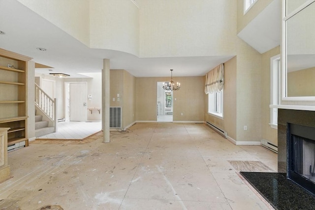 2 Hillside Dr Unit 2, Wayland, MA 01778 - unfurnished living room with a baseboard heating unit, a high ceiling, a fireplace with flush hearth, stairs, and a chandelier