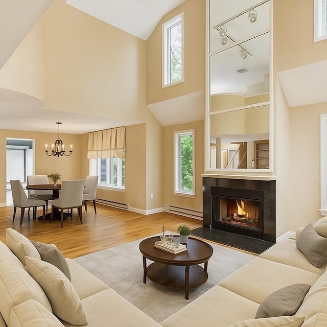 2 Hillside Dr Unit 2, Wayland, MA 01778 - living room featuring a baseboard radiator, wood finished floors, high vaulted ceiling, and healthy amount of natural light