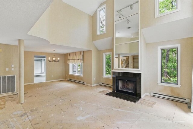 2 Hillside Dr Unit 2, Wayland, MA 01778 - unfurnished living room featuring a baseboard heating unit, a fireplace, a chandelier, and a towering ceiling