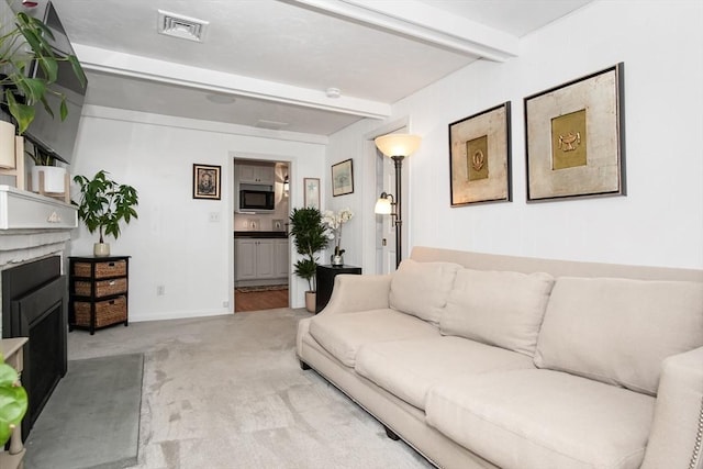 living room featuring carpet floors, a fireplace, visible vents, beamed ceiling, and baseboards