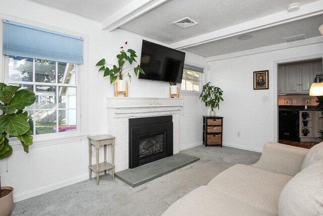 living room with visible vents, a fireplace, baseboards, and beamed ceiling