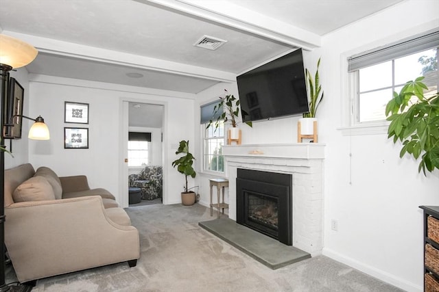 living room with a brick fireplace, baseboards, visible vents, and light colored carpet