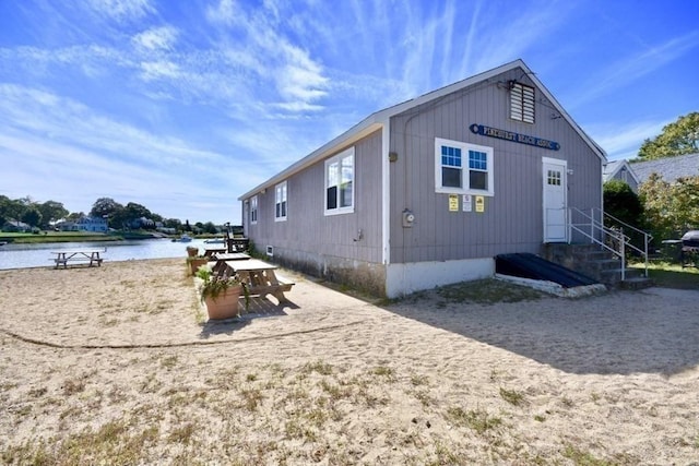 view of side of home with entry steps and a water view