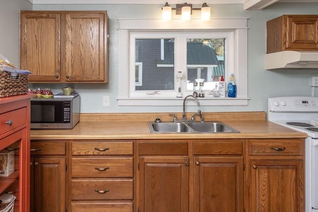 kitchen featuring a sink, brown cabinets, and white range with electric cooktop