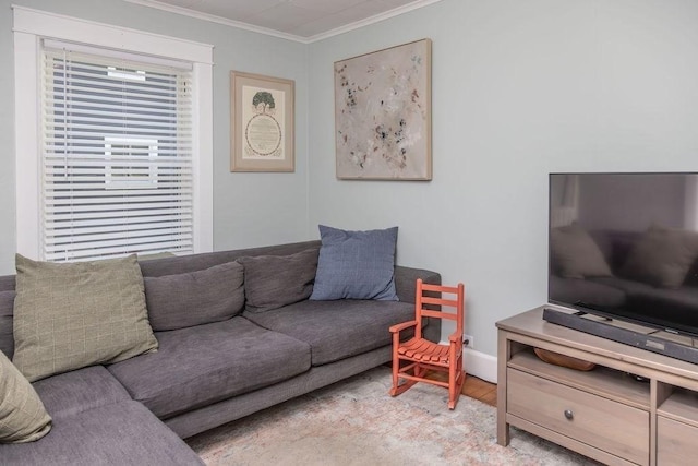 living area with crown molding, baseboards, and wood finished floors