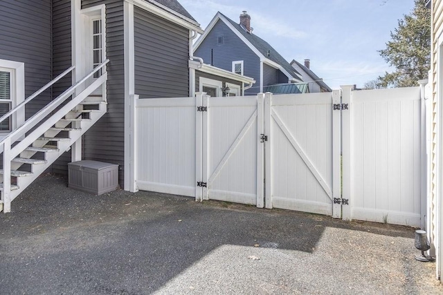 view of gate with fence and stairs