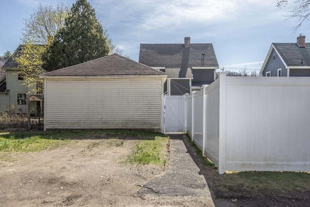 view of home's exterior featuring fence, a chimney, and roof with shingles