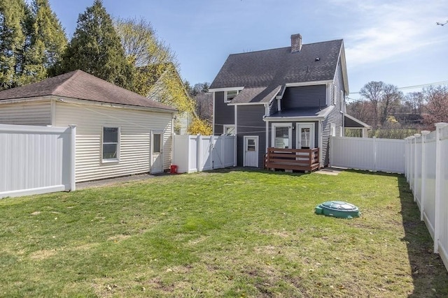 rear view of house with a shingled roof, a gate, a fenced backyard, and a chimney