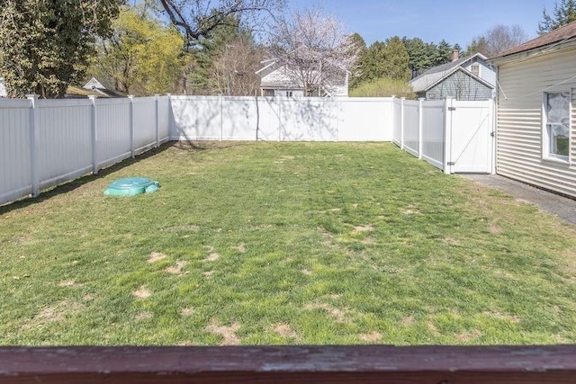 view of yard with a fenced backyard and a gate