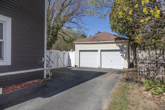 detached garage with fence and a gate
