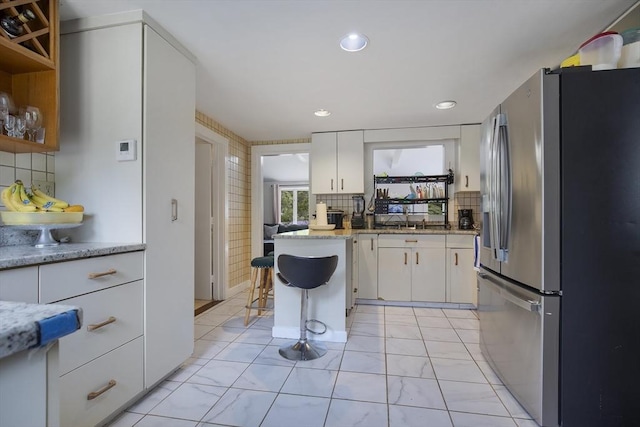 298 Oakland Rd, Barnstable, MA 02601 - kitchen with stainless steel refrigerator with ice dispenser, white cabinetry, tasteful backsplash, and recessed lighting