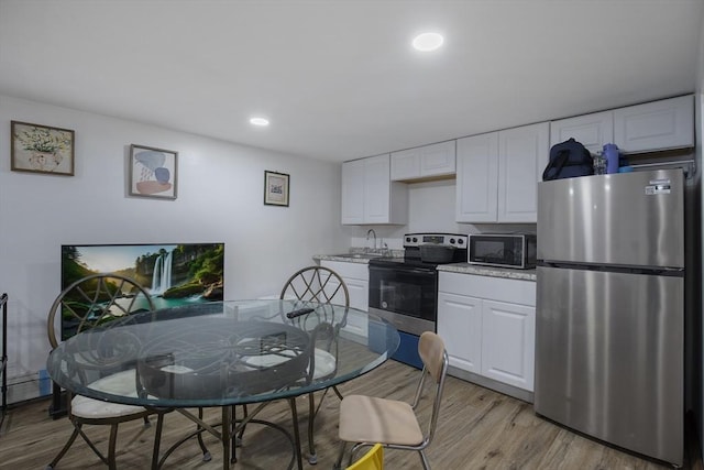 298 Oakland Rd, Barnstable, MA 02601 - kitchen featuring stainless steel appliances, a sink, light wood-type flooring, white cabinets, and recessed lighting