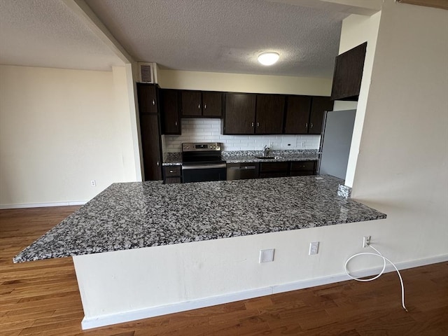 60 Longwood Ave Unit 802, Brookline, MA 02446 - kitchen with appliances with stainless steel finishes, tasteful backsplash, a textured ceiling, wood finished floors, and dark stone counters