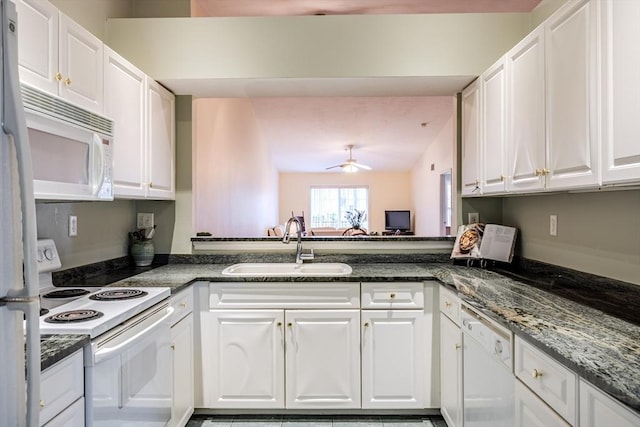 kitchen with white appliances, ceiling fan, sink, dark stone countertops, and white cabinets