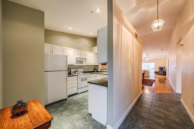 kitchen featuring white appliances, ceiling fan, decorative light fixtures, dark tile patterned flooring, and white cabinetry