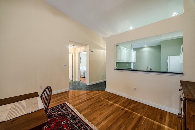 dining area featuring hardwood / wood-style flooring and vaulted ceiling