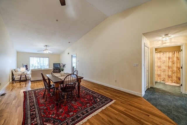 dining space with ceiling fan, wood-type flooring, and vaulted ceiling