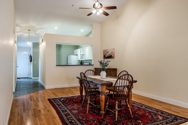 dining area featuring ceiling fan, high vaulted ceiling, and wood-type flooring