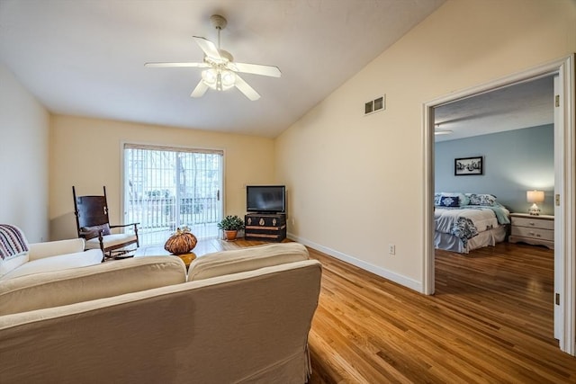 living room featuring wood-type flooring, vaulted ceiling, and ceiling fan