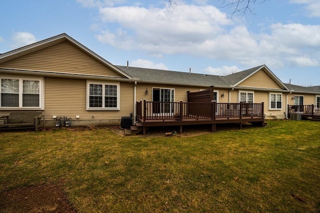 back of property with a deck and a yard