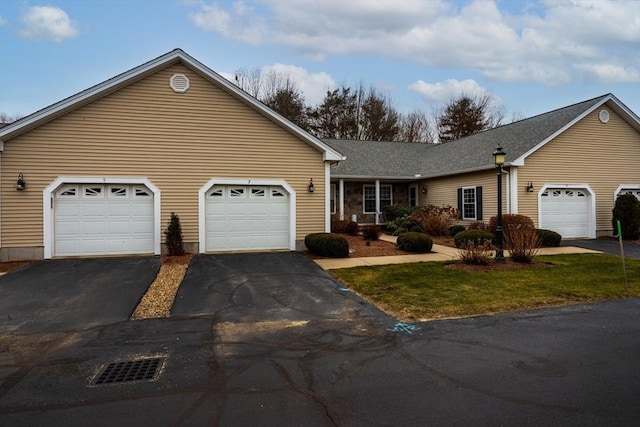 single story home with a garage and a front lawn