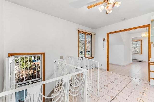hall featuring baseboards, a healthy amount of sunlight, and baseboard heating