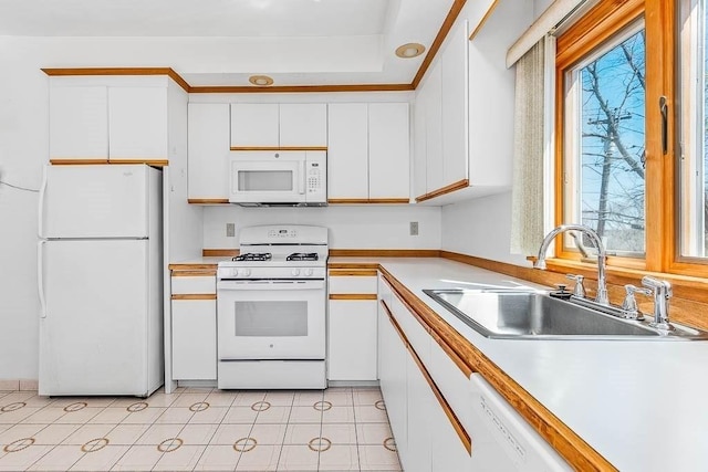 kitchen featuring a sink, light countertops, white cabinets, and white appliances
