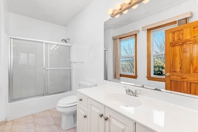 bathroom featuring vanity, shower / bath combination with glass door, tile patterned floors, and toilet
