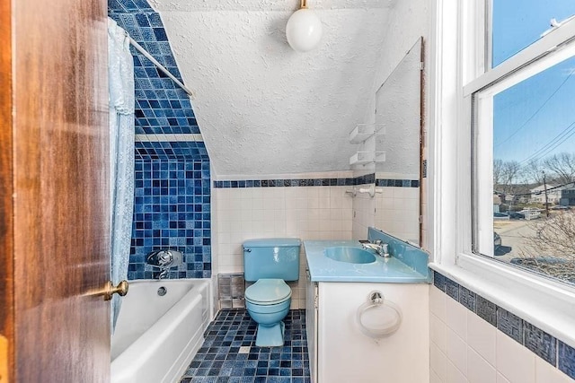 bathroom featuring vanity, toilet, tile walls, plenty of natural light, and tile patterned floors